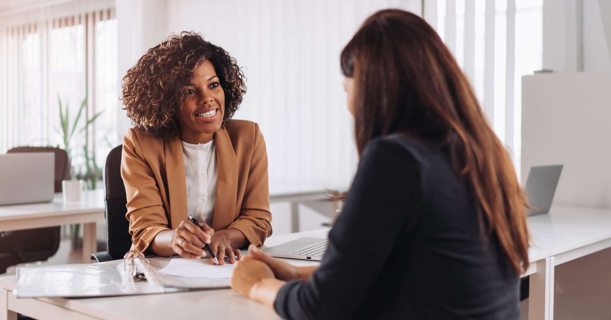 Two females in conversation at desk