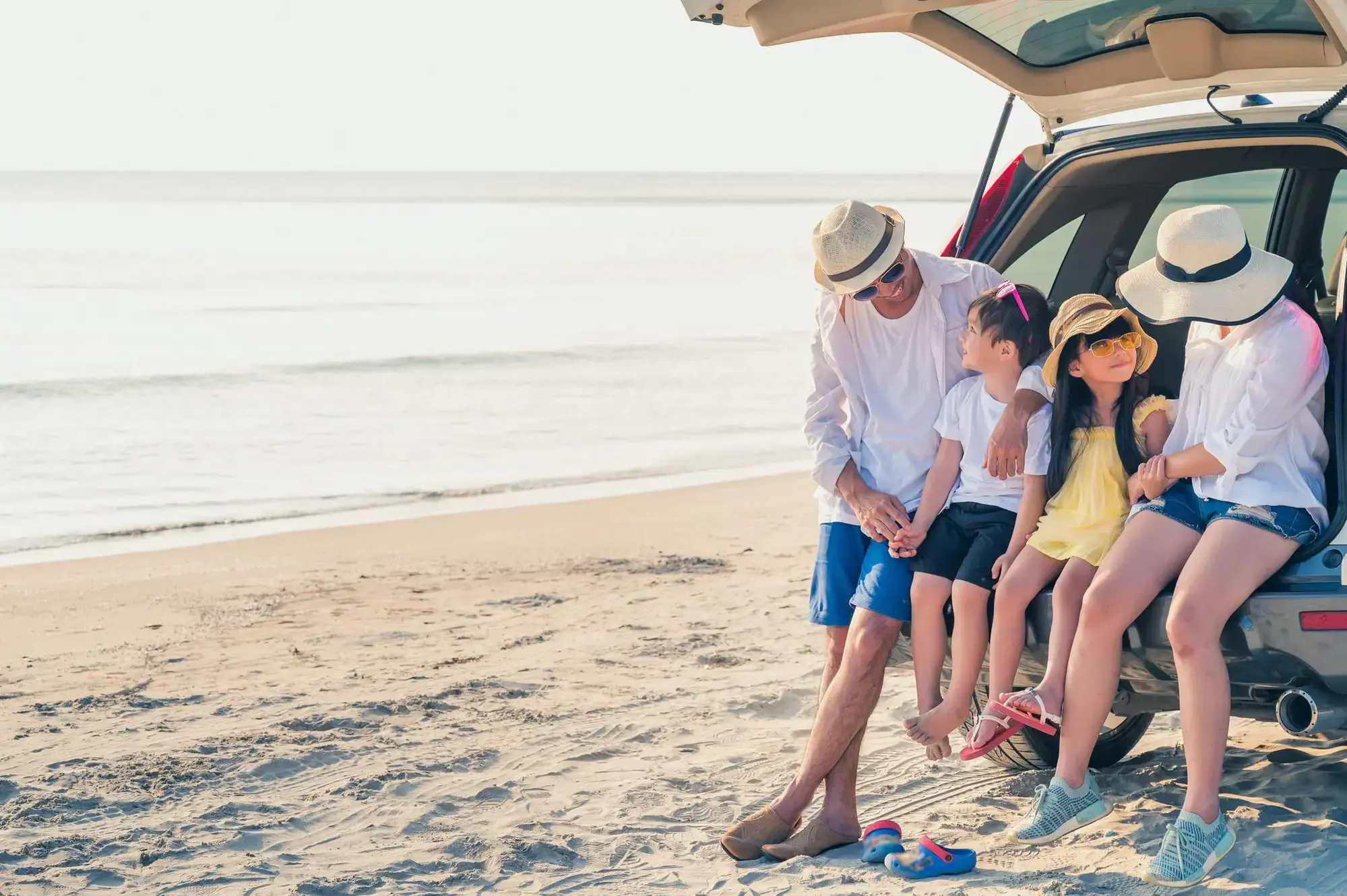 Family sitting in boot of car 